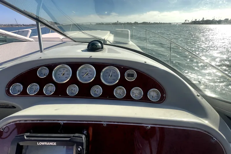Slide: The Image of Dashboard view of a 2007 Bayliner 305 boat with gauges and water in the background. - 6