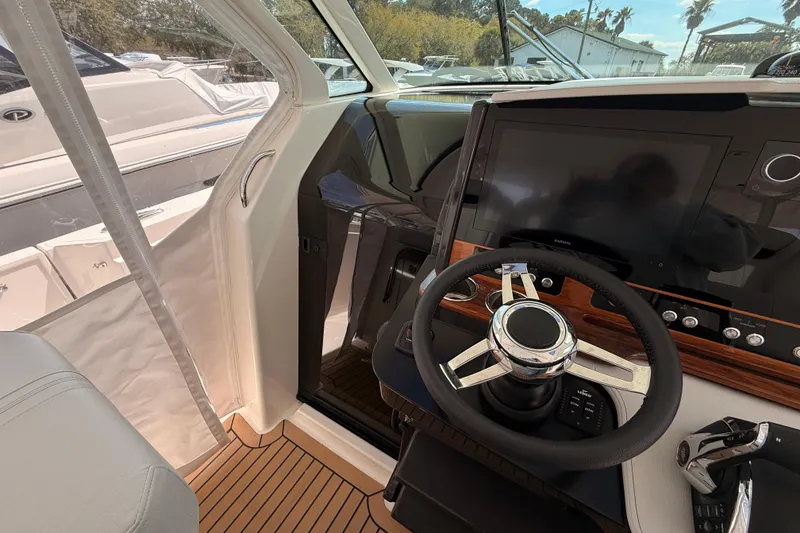 Slide: The Image of 2022 Tiara Yachts 38 LS helm with modern steering and navigation display. - 12