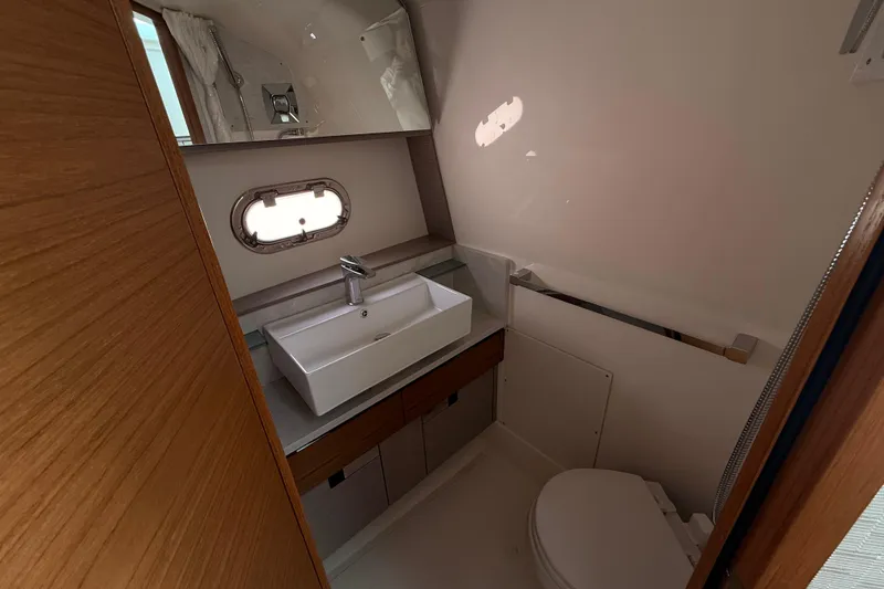 Slide: The Image of 2022 Tiara Yachts 38 LS bathroom with modern sink and porthole window. - 14