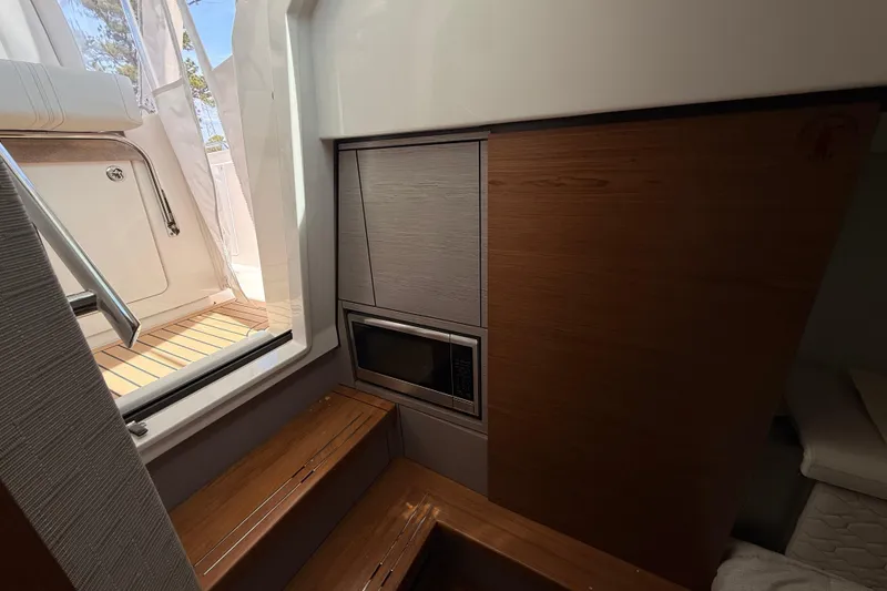 Slide: The Image of Interior of 2022 Tiara Yachts 38 LS, featuring wooden steps and built-in microwave. - 15