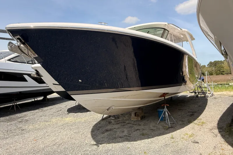 Slide: The Image of 2022 Tiara Yachts 38 LS boat on dry dock, side view under clear sky. - 2