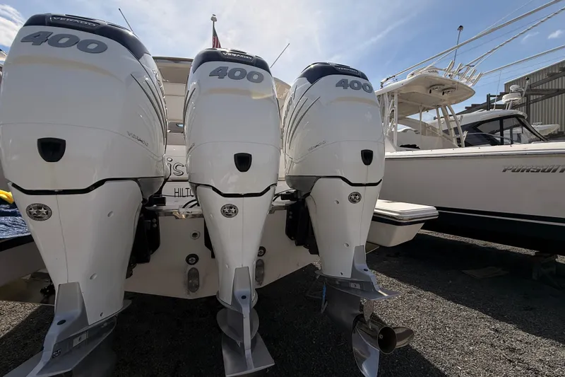 Slide: The Image of Triple outboard engines on a 2022 Tiara Yachts 38 LS, docked beside another boat. - 21
