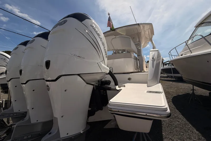 Slide: The Image of 2022 Tiara Yachts 38 LS with powerful outboard engines, docked under a clear sky. - 22