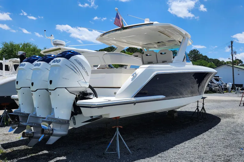 Slide: The Image of 2022 Tiara Yachts 38 LS with triple Mercury outboard engines, docked under a clear blue sky. - 25