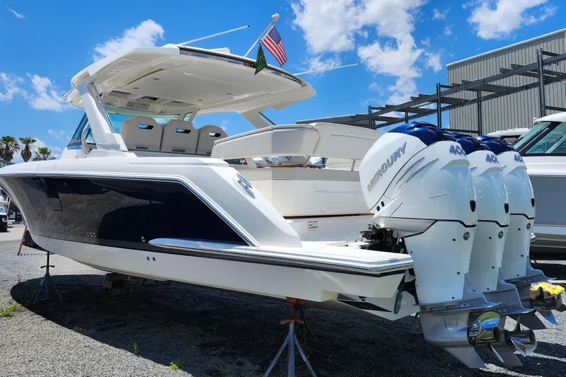 Slide: The Image of 2022 Tiara Yachts 38 LS with triple Mercury engines, docked under a clear blue sky. - 27