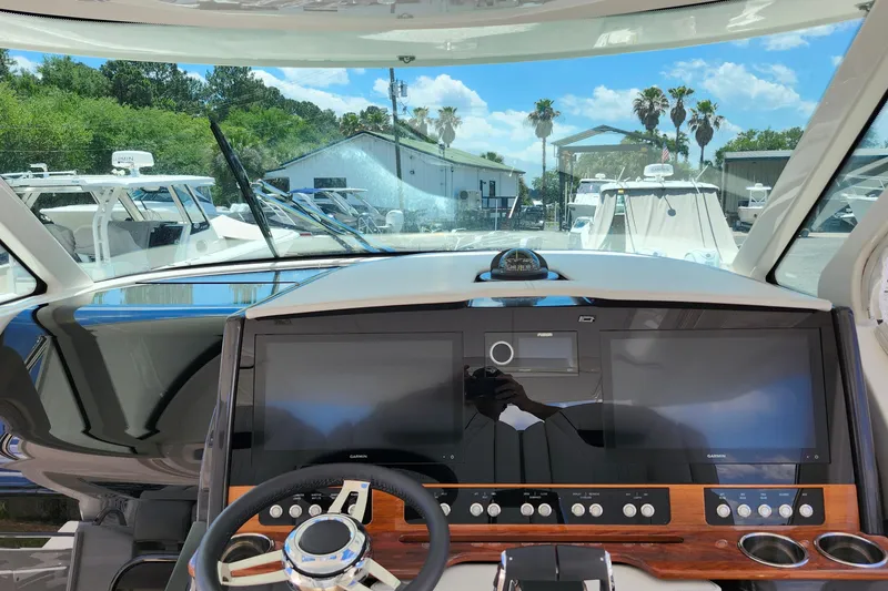 Slide: The Image of Helm of 2022 Tiara Yachts 38 LS with advanced navigation displays and controls. - 38