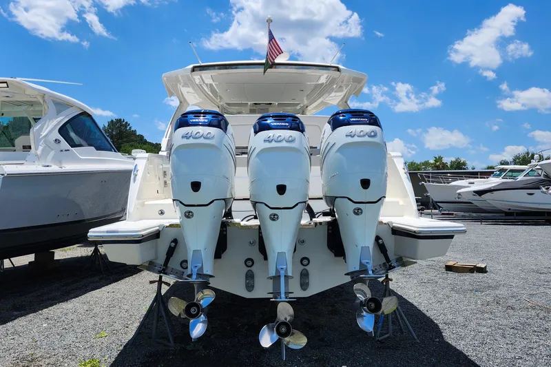 Slide: The Image of 2022 Tiara Yachts 38 LS with triple 400 horsepower engines, docked under a clear blue sky. - 42