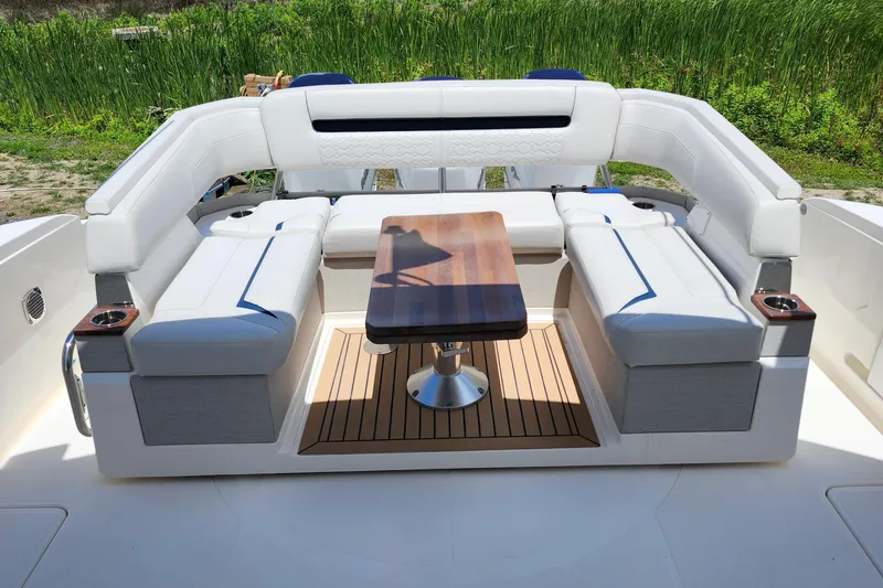Slide: The Image of Luxurious seating area on 2022 Tiara Yachts 38 LS with wooden table and white cushions. - 46