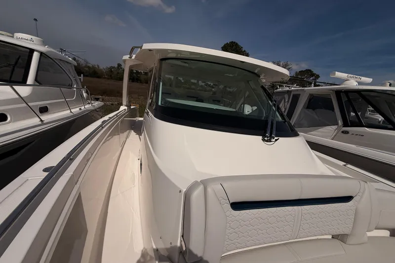 Slide: The Image of 2022 Tiara Yachts 38 LS boat, sleek design, docked alongside similar vessels. - 6