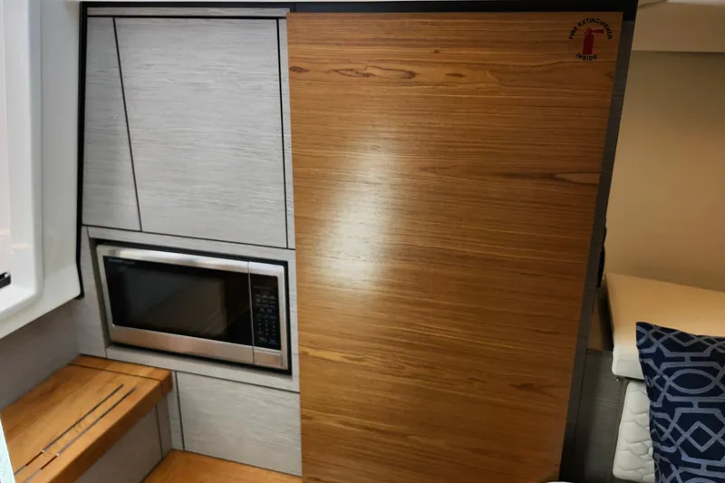 Slide: The Image of 2022 Tiara Yachts 38 LS interior with microwave and wood paneling. - 66
