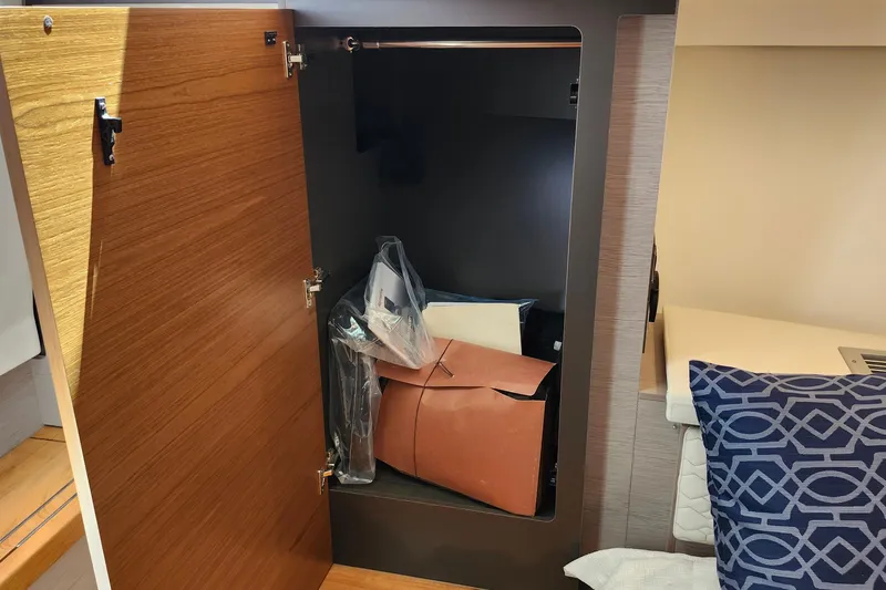 Slide: The Image of Open storage compartment on 2022 Tiara Yachts 38 LS, featuring wooden door and interior items. - 67