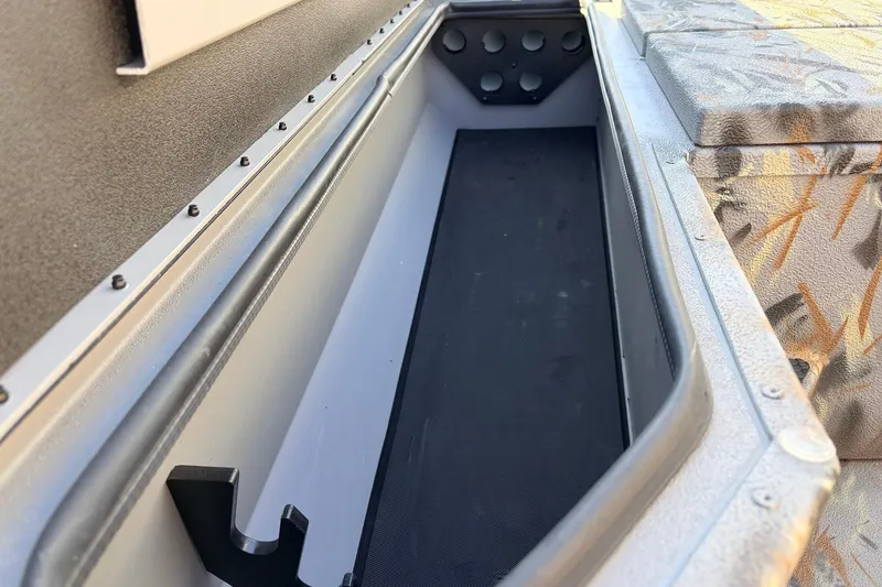 Slide: The Image of 2025 Ranger RB210 boat storage compartment with camo seating and durable construction. - 19