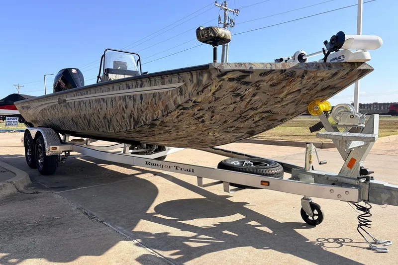 Slide: The Image of 2025 Ranger RB210 boat with camouflage design on a trailer, parked outdoors. - 3