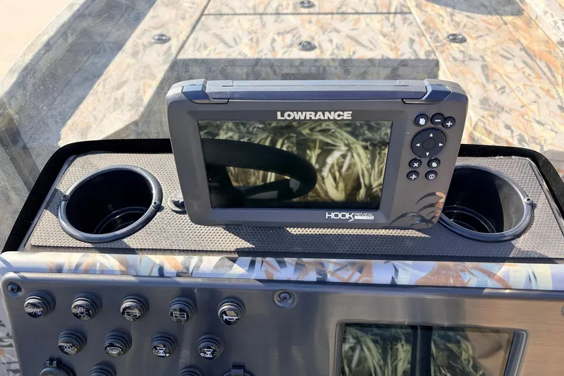 Slide: The Image of Fishfinder on 2025 Ranger RB210 boat dashboard with control panel and cup holders. - 35