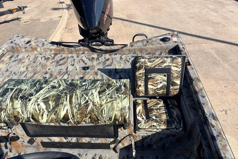 Slide: The Image of 2025 Ranger RB210 boat with camouflage seating and motor, parked on concrete. - 43