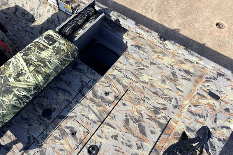 Slide: The Image of 2025 Ranger RB210 boat interior with camouflage seating and storage compartments. - 44