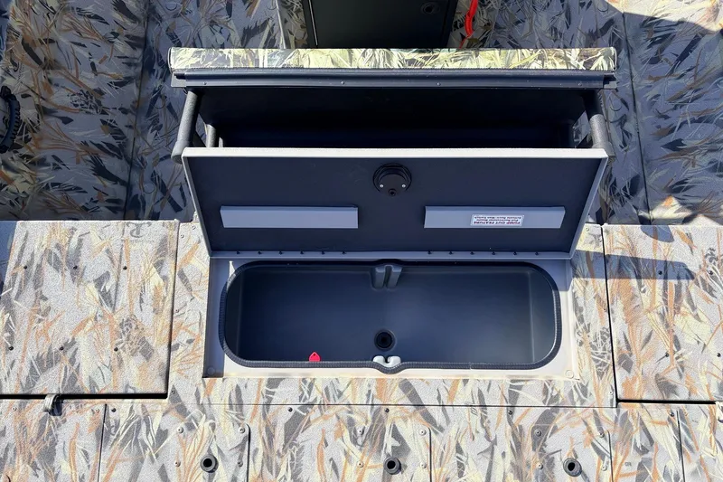 Slide: The Image of 2025 Ranger RB210 boat storage compartment with camouflage design, open lid revealing interior. - 50