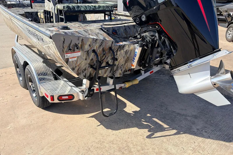 Slide: The Image of 2025 Ranger RB210 boat on trailer, featuring powerful outboard motor and camouflage design. - 8