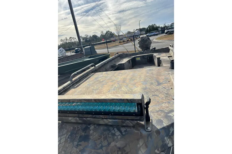 Slide: The Image of 2023 Excel 1754 Shallow Water F4 boat with camouflage pattern, parked outdoors. - 19