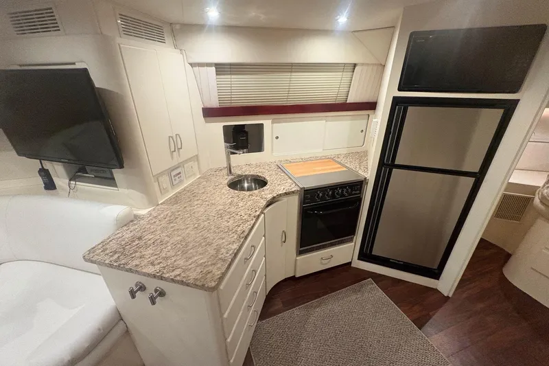 Slide: The Image of Interior of 1996 Carver 38 Santego yacht with white seating and wooden table. - 16