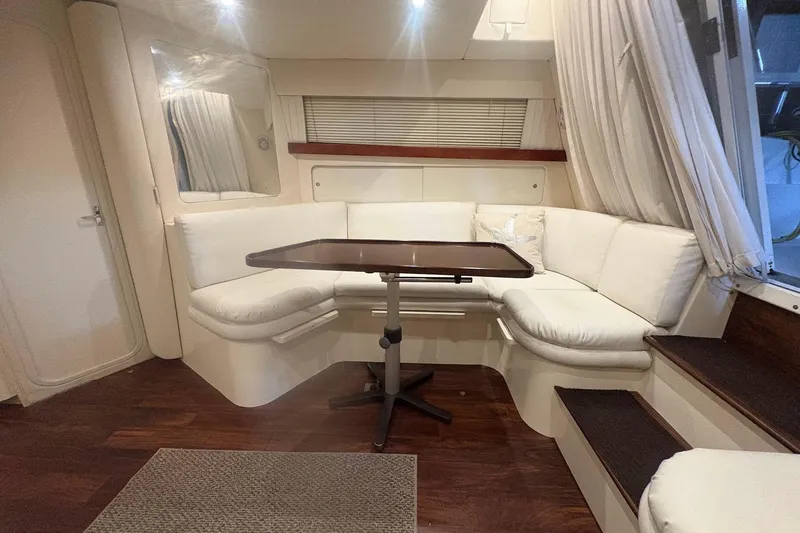 Slide: The Image of Interior of 1996 Carver 38 Santego yacht with white seating and wooden table. - 18