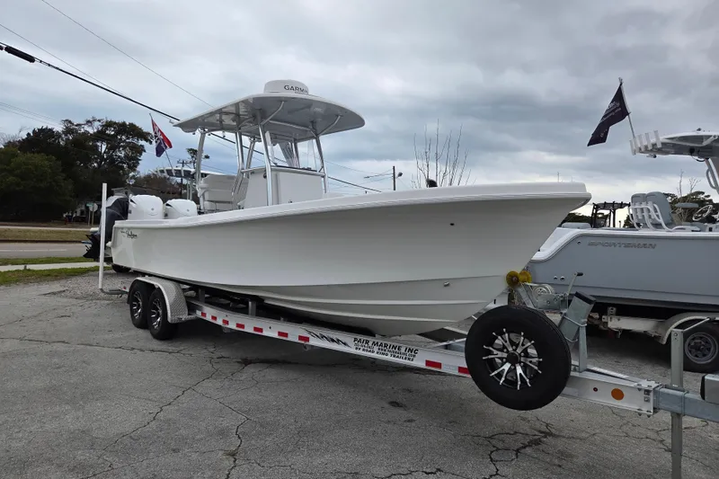 Slide: The Image of 2024 Pair Customs 27 Center Console boat on trailer, overcast sky background. - 2