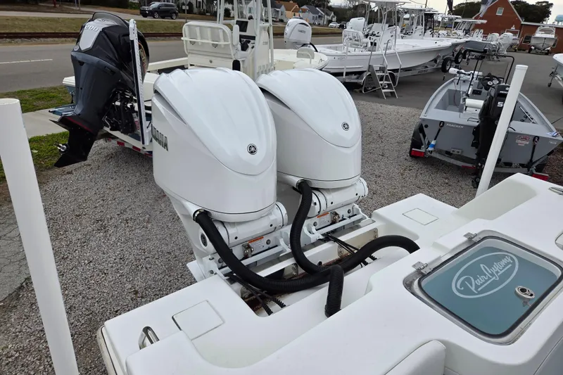 Slide: The Image of 2024 Pair Customs 27 Center Console with dual outboard engines displayed outdoors. - 5