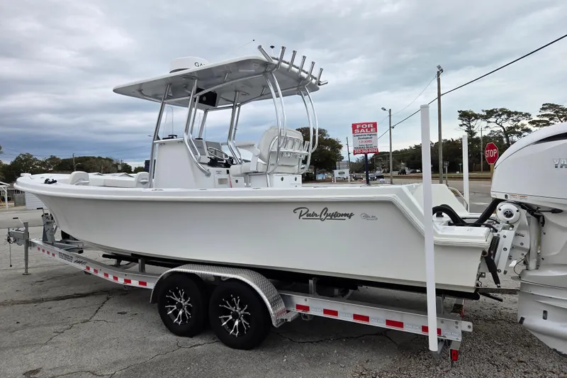 Slide: The Image of 2024 Pair Customs 27 Center Console boat on trailer, for sale sign visible. - 6