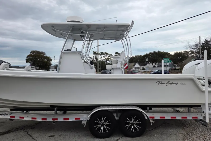 Slide: The Image of 2024 Pair Customs 27 Center Console boat on trailer, side view, overcast sky. - 7