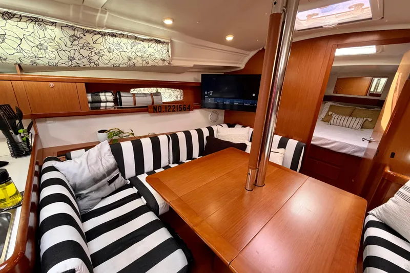 Slide: The Image of Interior of 2008 Beneteau Oceanis 37 yacht with striped seating and wooden table. - 10