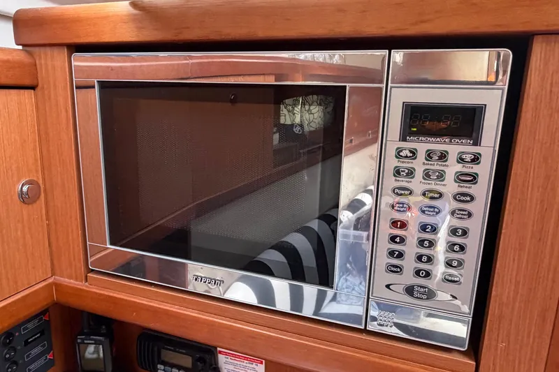 Slide: The Image of Microwave oven in 2008 Beneteau Oceanis 37 yacht kitchen, surrounded by wooden cabinetry. - 13