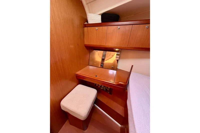 Slide: The Image of Cozy cabin interior of 2008 Beneteau Oceanis 37 with wooden desk and cushioned stool. - 16