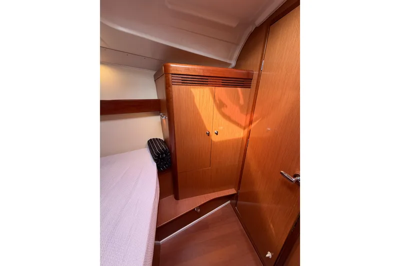 Slide: The Image of 2008 Beneteau Oceanis 37 cabin interior with wooden cabinetry and cozy sleeping area. - 19