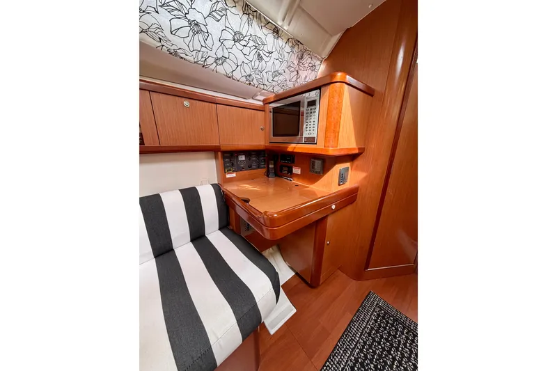 Slide: The Image of Interior of 2008 Beneteau Oceanis 37 yacht with striped seating and wooden cabinetry. - 21
