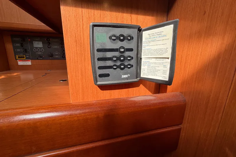 Slide: The Image of Control panel inside a 2008 Beneteau Oceanis 37 yacht, featuring wood finish and SMXir system. - 23