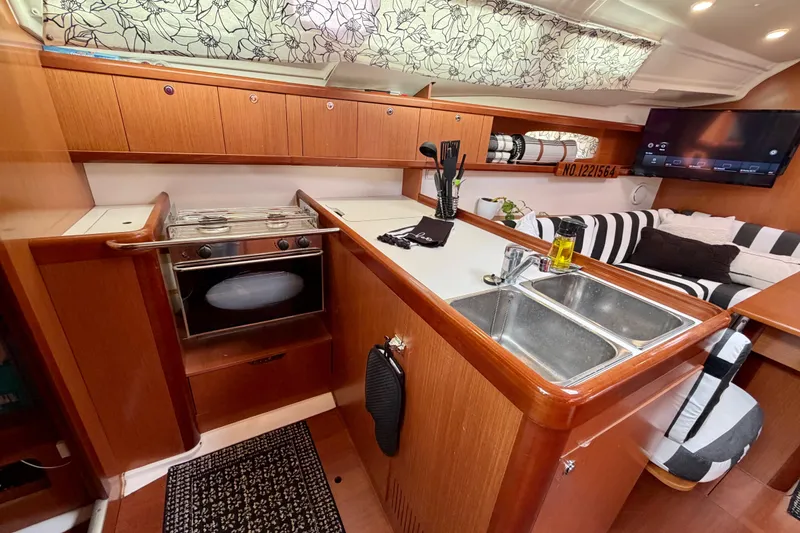 Slide: The Image of 2008 Beneteau Oceanis 37 yacht interior with modern kitchen and cozy seating area. - 25