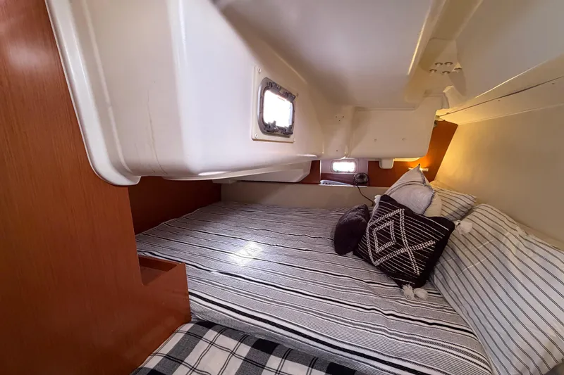 Slide: The Image of Cozy cabin interior of 2008 Beneteau Oceanis 37 sailboat with striped bedding and pillows. - 30