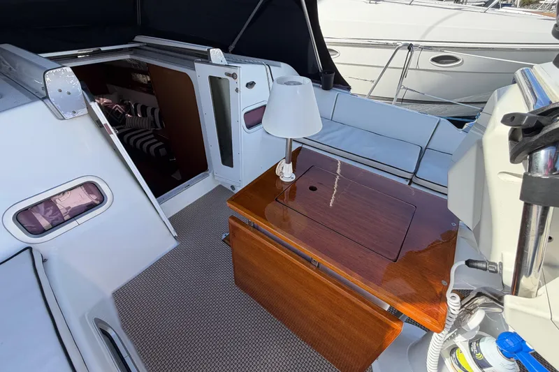 Slide: The Image of 2008 Beneteau Oceanis 37 yacht cockpit with wooden table and cabin entrance. - 36