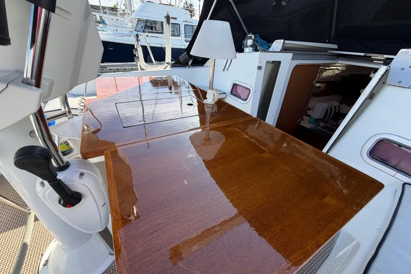Slide: The Image of 2008 Beneteau Oceanis 37 cockpit with polished wooden table and open cabin entrance. - 39