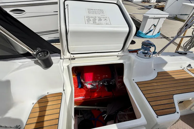 Slide: The Image of Open storage compartment on 2008 Beneteau Oceanis 37 sailboat, featuring wooden deck and winch. - 43