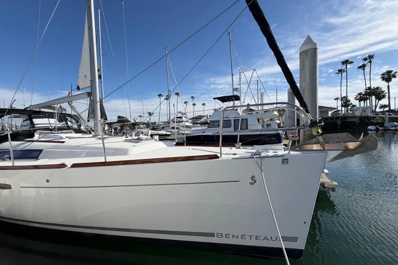 Slide: The Image of 2008 Beneteau Oceanis 37 sailboat docked in a marina under a clear blue sky. - 58