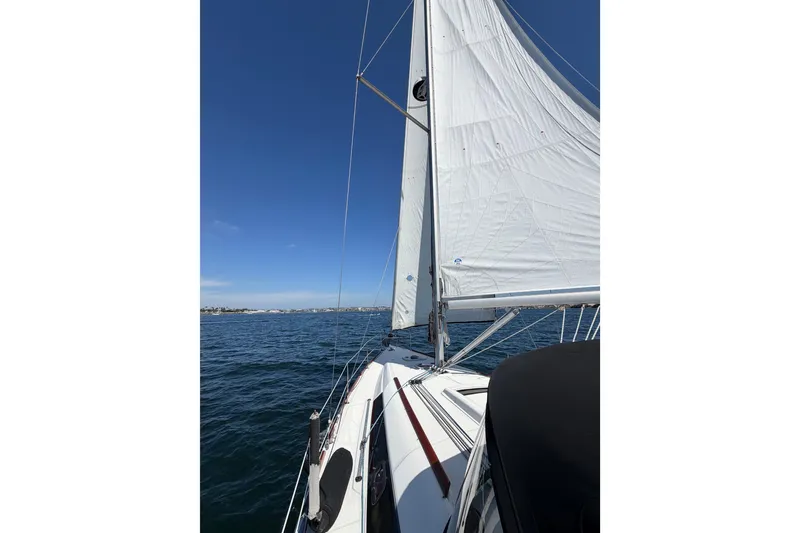 Slide: The Image of 2008 Beneteau Oceanis 37 sailboat on open water under clear blue sky. - 59