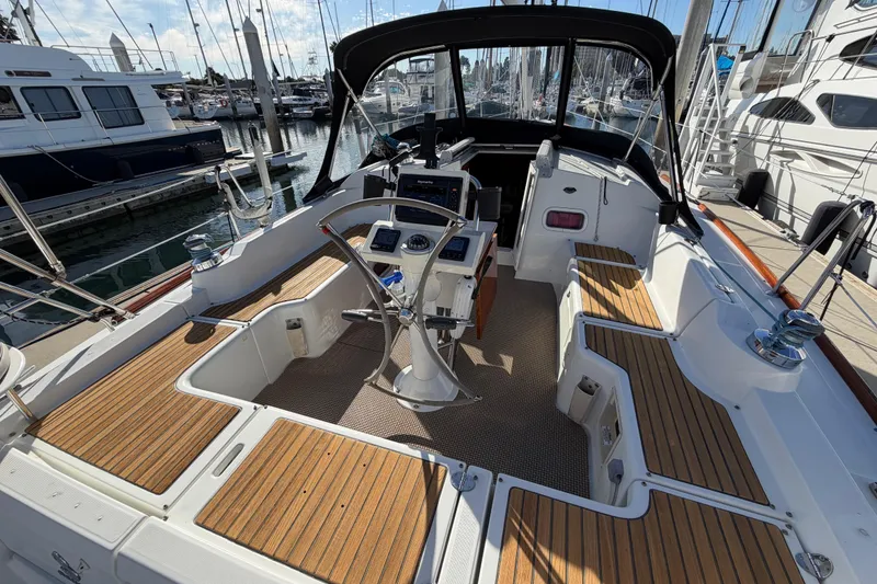 Slide: The Image of 2008 Beneteau Oceanis 37 sailboat cockpit with wooden seating and steering wheel. - 7
