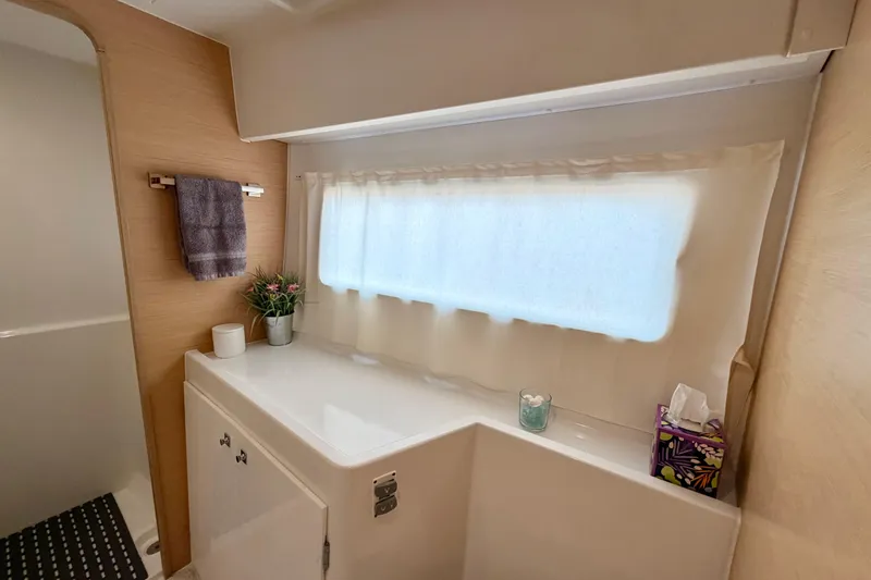 Slide: The Image of Bathroom interior of 2017 Lagoon 42 catamaran with window, towel, and decor. - 22