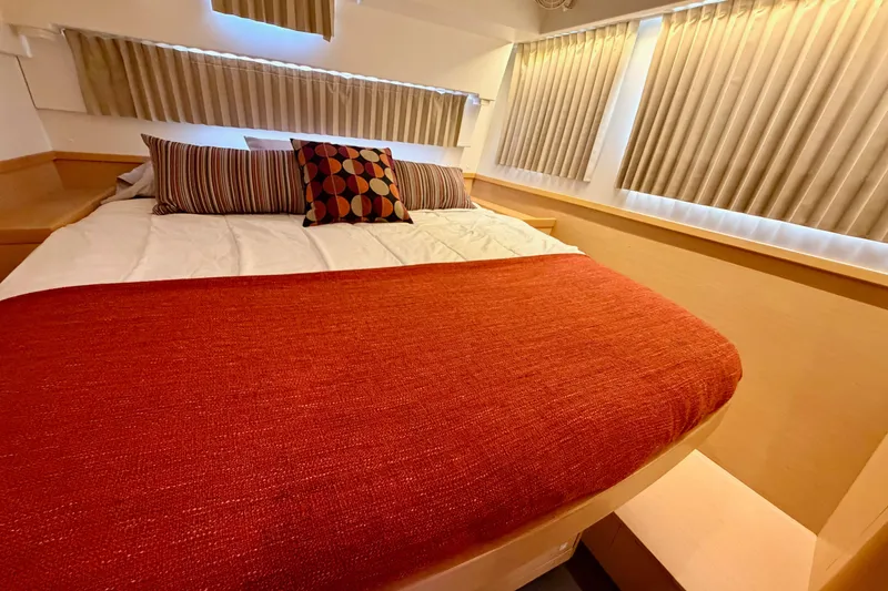 Slide: The Image of Cozy bedroom interior of 2017 Lagoon 42 catamaran with red bedding and striped pillows. - 26