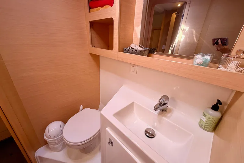 Slide: The Image of Bathroom interior of 2017 Lagoon 42 catamaran with sink, toilet, and storage shelves. - 28