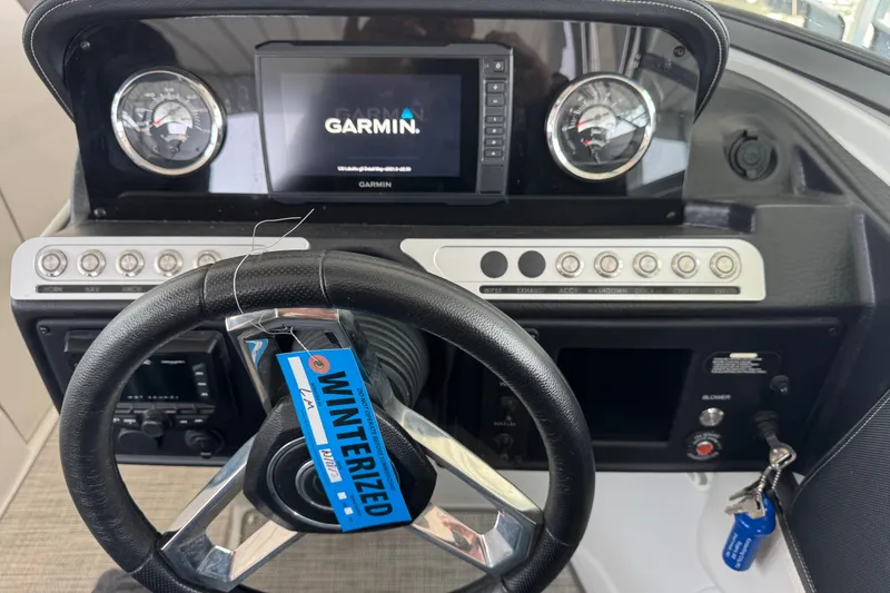 Slide: The Image of 2022 Crownline 265 SS dashboard with Garmin display and winterized tag. - 24