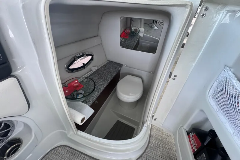 Slide: The Image of 2022 Crownline 265 SS boat interior bathroom with toilet, mirror, and storage. - 30