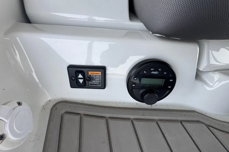 Slide: The Image of 2022 Crownline 265 SS boat control panel with warning label and audio system. - 33