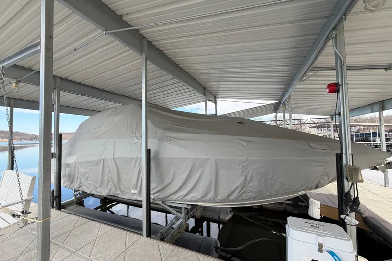Slide: The Image of Covered 2022 Crownline 265 SS boat docked under a metal canopy. - 4